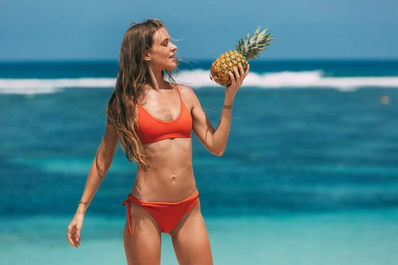 a woman in a bikini holding a pineapple, pexels contest winner, physical : tinyest midriff ever, coral, 🦩🪐🐞👩🏻🦳, holly bruce
