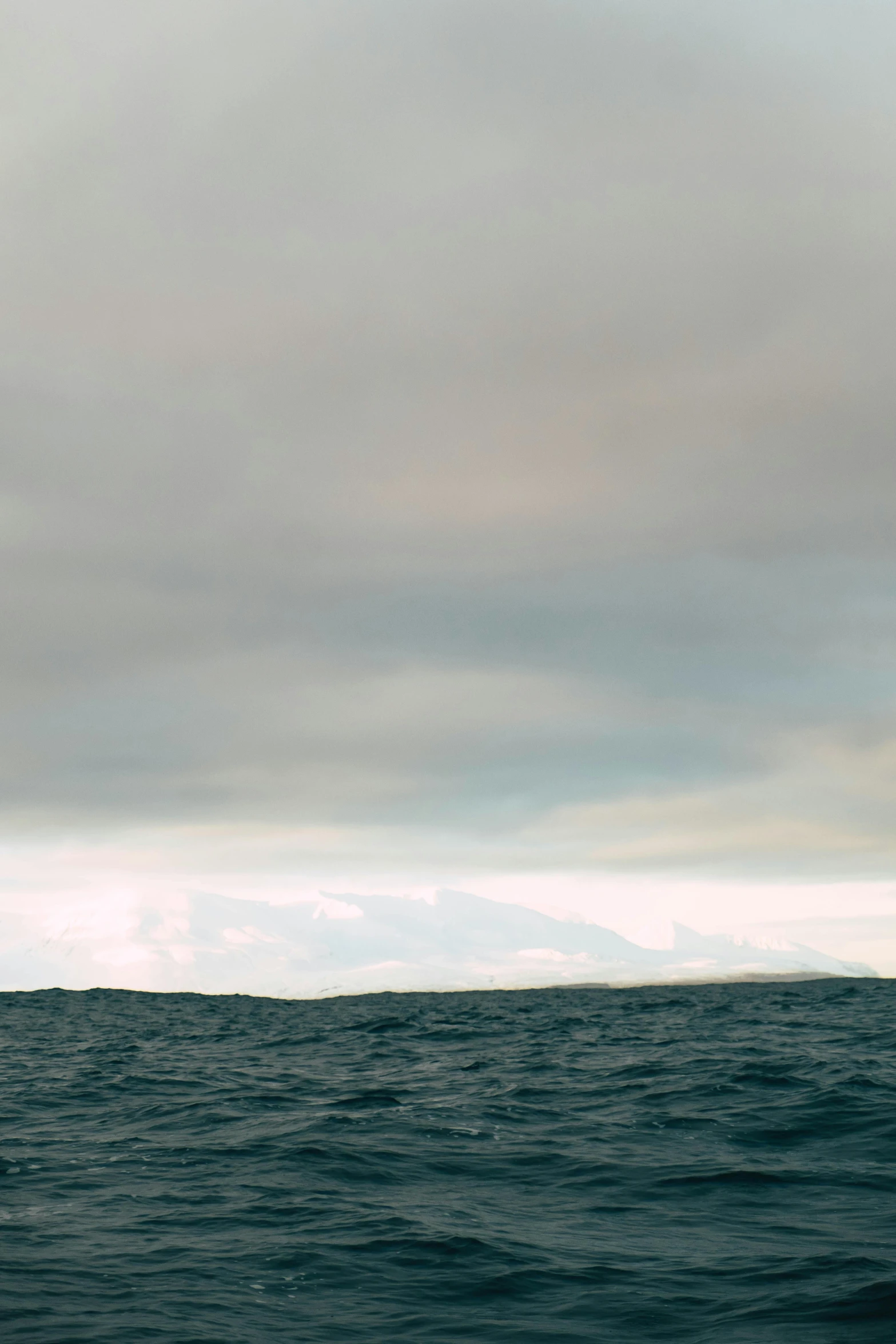 a man riding a surfboard on top of a wave, an album cover, unsplash, minimalism, brooding clouds, panorama, photo taken from a boat, skye meaker