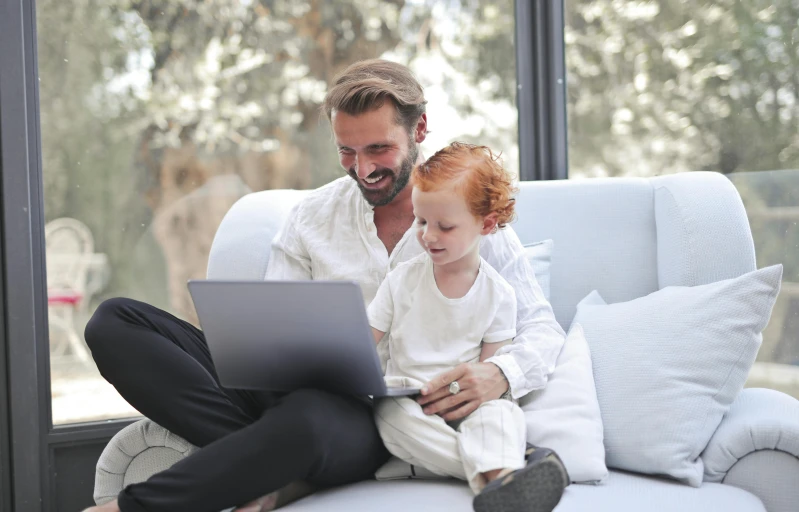 a man and a child sitting on a couch with a laptop, pexels, hr ginger, raphael lecoste, casually dressed, decorative