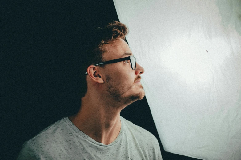 a man standing in front of a white backdrop, pexels contest winner, hyperrealism, underexposed lighting, profile pic, with glasses, lachlan bailey