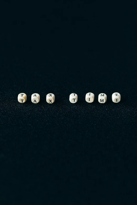 a row of dices sitting on top of a black surface, an album cover, inspired by Cerith Wyn Evans, unsplash, realism, earrings, letters, jewelry pearls, ffffound