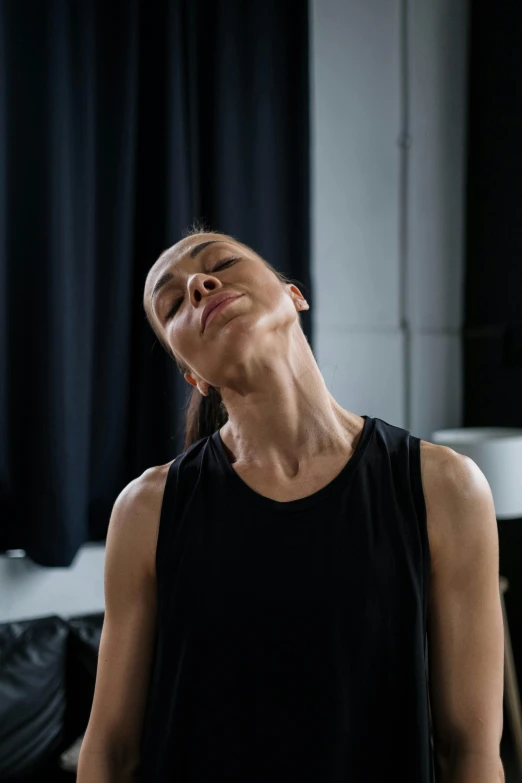 a woman sitting on a bed with her eyes closed, by Nina Hamnett, trending on unsplash, hyperrealism, muscular neck, dance meditation, movie still of a snarling, neck zoomed in from lips down