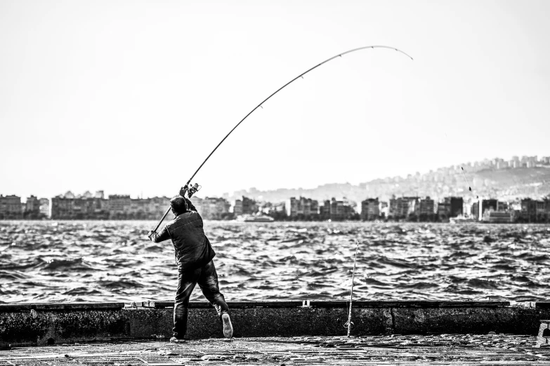 a black and white photo of a man fishing, by Mathias Kollros, pexels contest winner, launching a straight ball, naples, mixed art, high quality upload