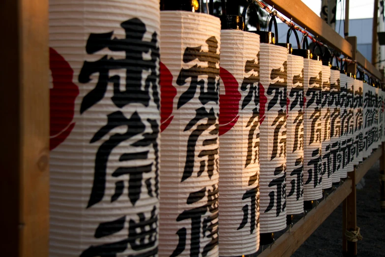 a row of paper lanterns with asian writing on them, unsplash, ukiyo-e, booze, at twilight, ryohji hase, wide screenshot