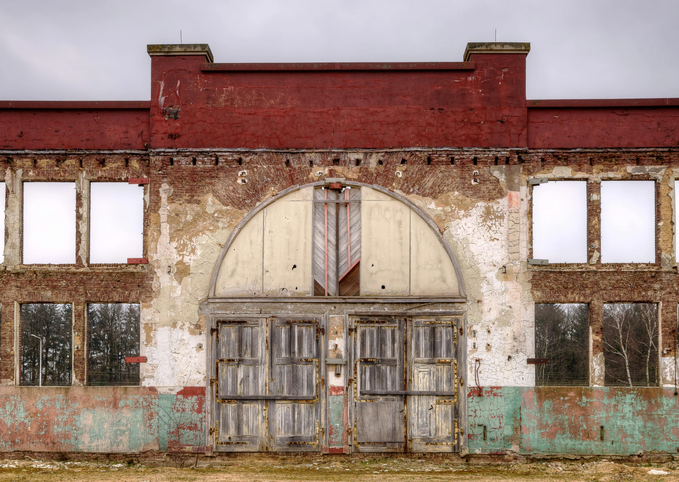 an old building with a fire hydrant in front of it, by Alison Geissler, pexels contest winner, arched doorway, abandoned circus, alabama, front face