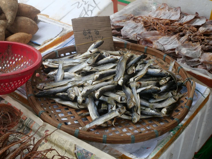 a basket full of fish sitting on top of a table, shenzhen, fan favorite, amanda lilleston, beans