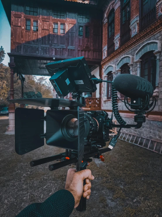 a person holding a camera in front of a building, pexels contest winner, video art, historical footage, cinematic outfit photo, today\'s featured photograph 4k, cinematic morning light