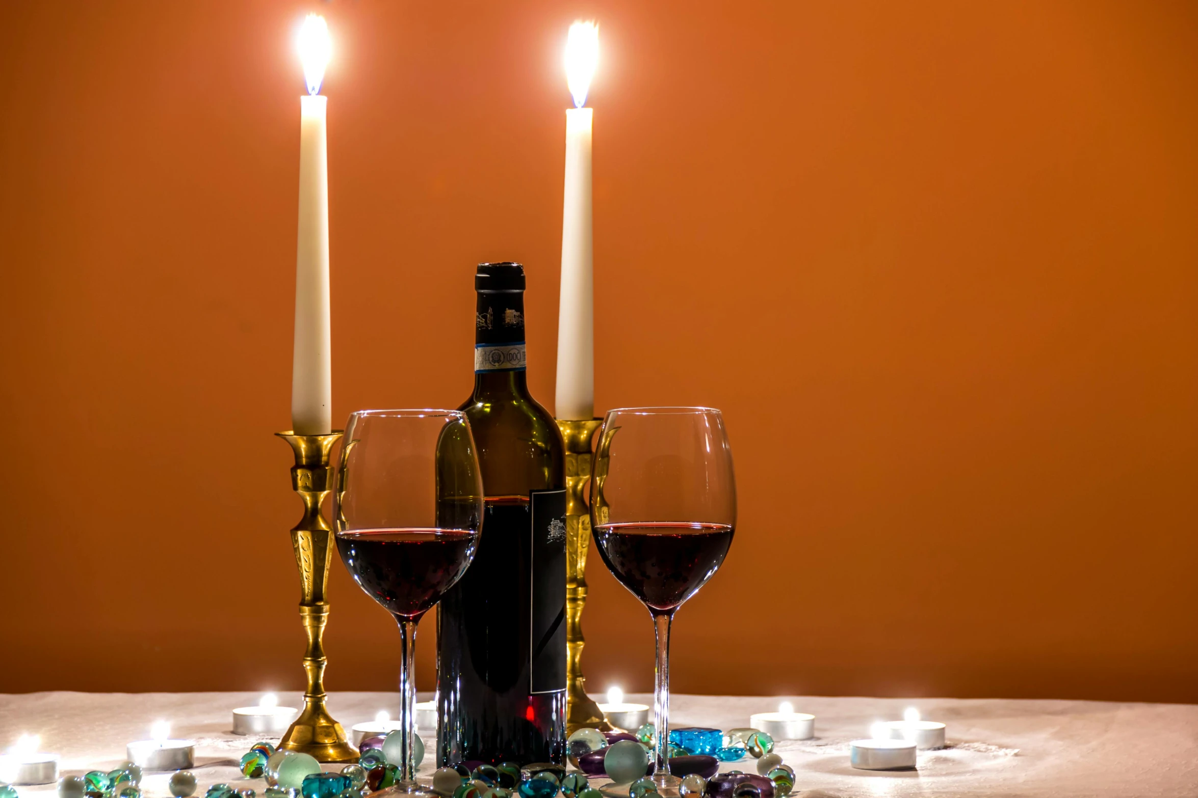 a table topped with two wine glasses and a bottle of wine, pexels contest winner, romanticism, natural candle lighting, gemstones and treasures, profile image, velvet tablecloth