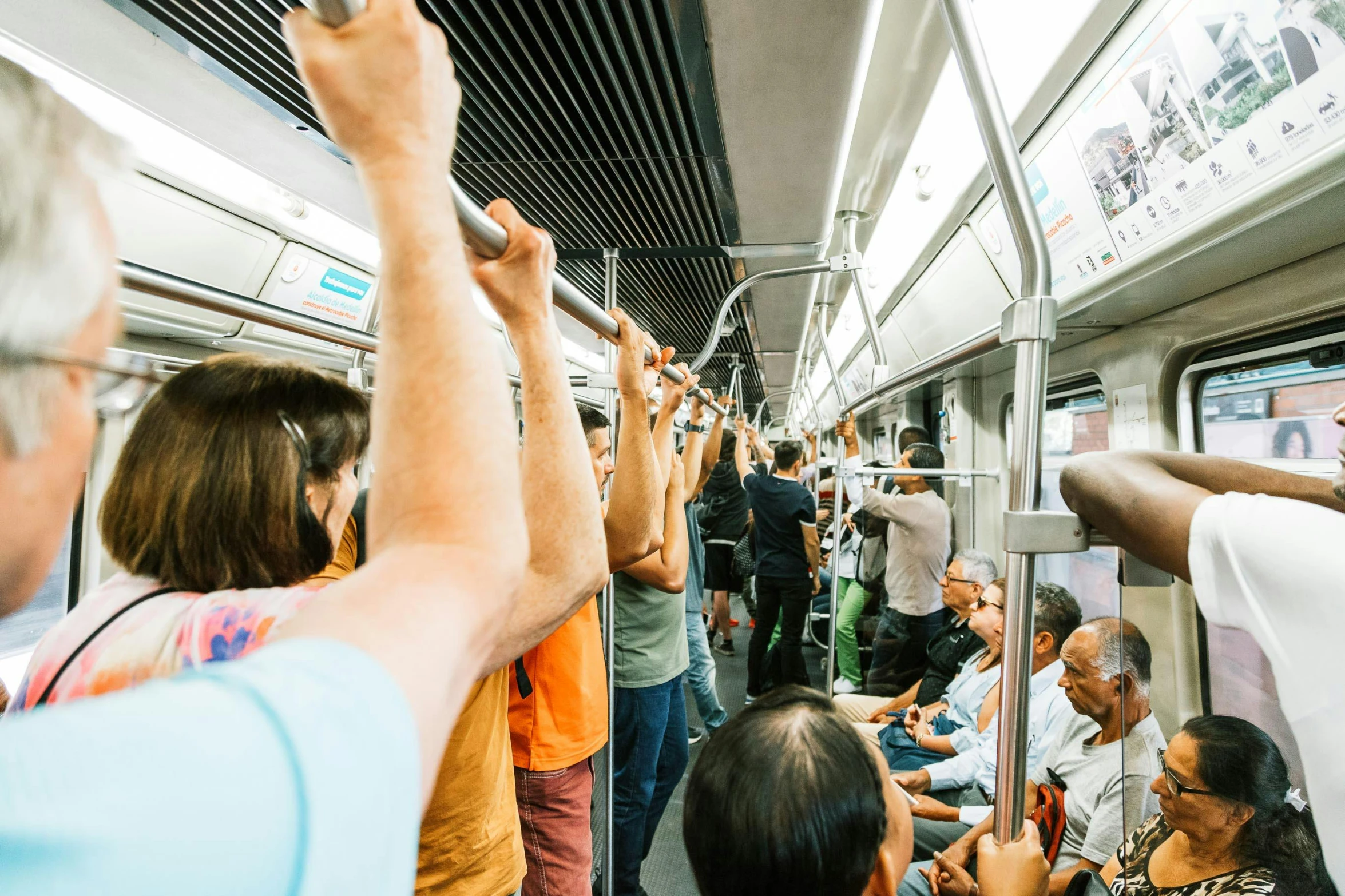 a group of people riding on a subway train, by Carey Morris, pexels contest winner, sao paulo, raising an arm, 🚿🗝📝