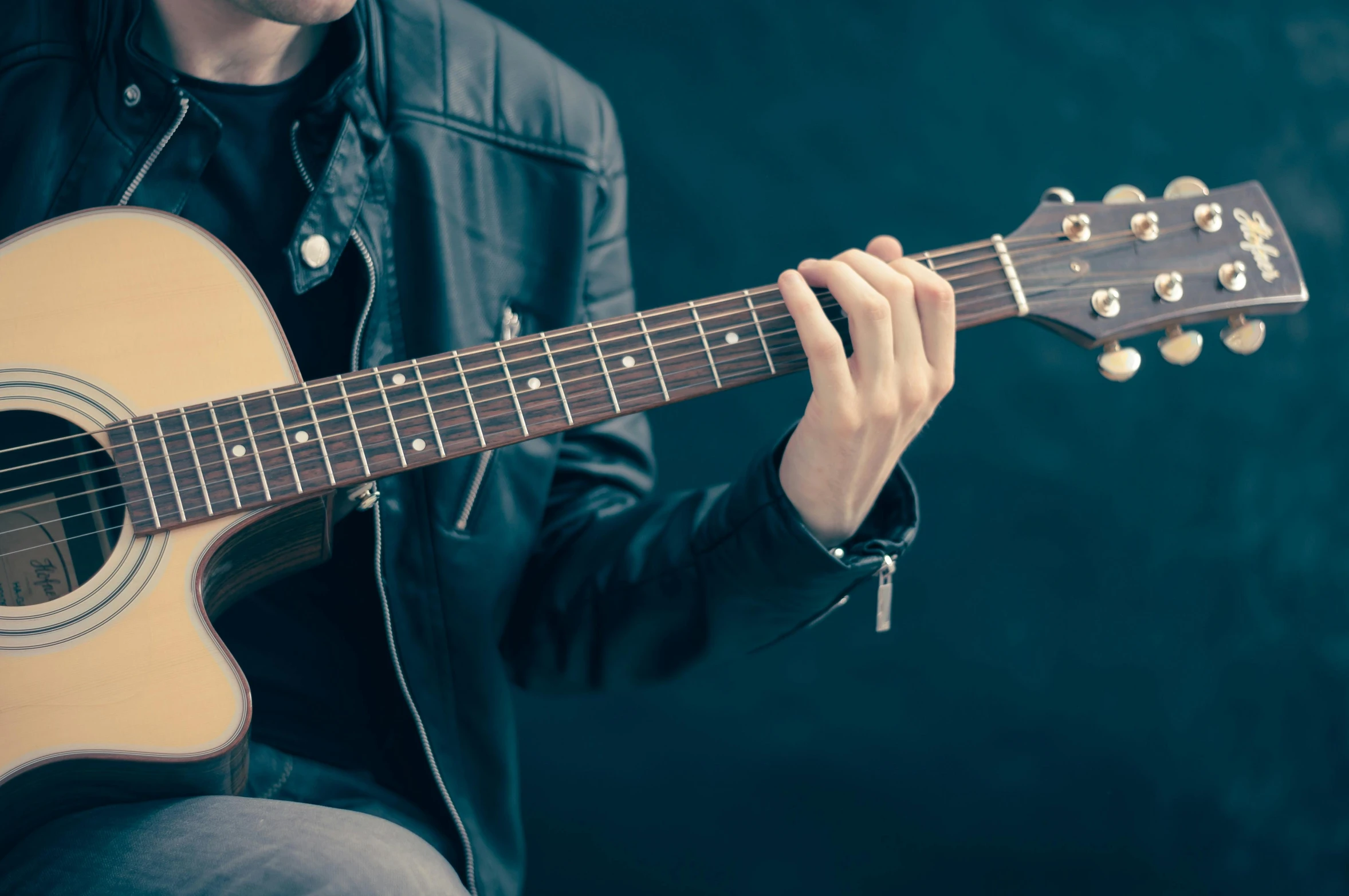 a man in a leather jacket playing a guitar, by Niko Henrichon, shutterstock, no - text no - logo, lachlan bailey, rectangle, student