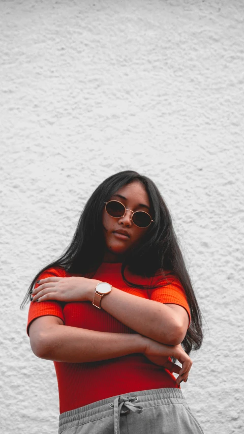 a woman standing in front of a white wall, an album cover, by Pablo Rey, trending on pexels, wearing orange sunglasses, long free black straight hair, 15081959 21121991 01012000 4k, black teenage girl