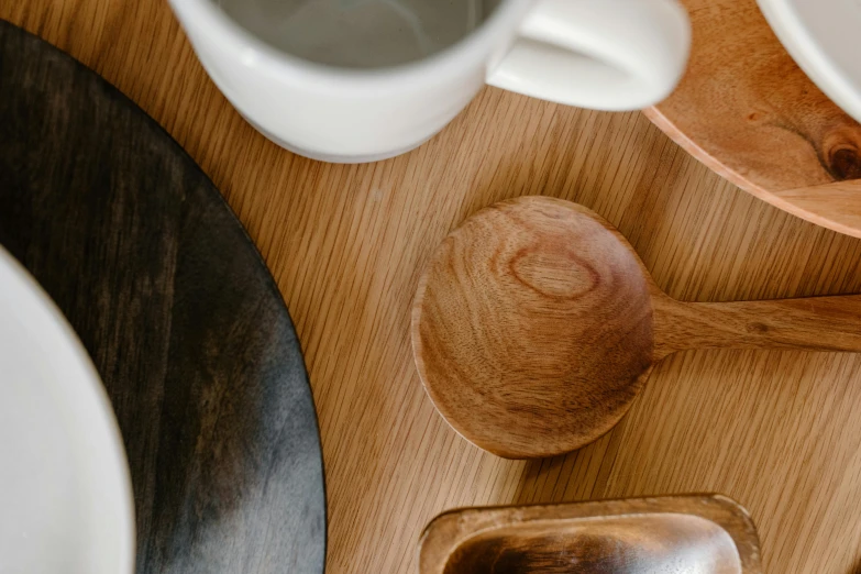 a wooden spoon sitting on top of a wooden table, a still life, inspired by Lewis Henry Meakin, trending on unsplash, white ceramic shapes, medium closeup, bog oak, smooth light from upper left