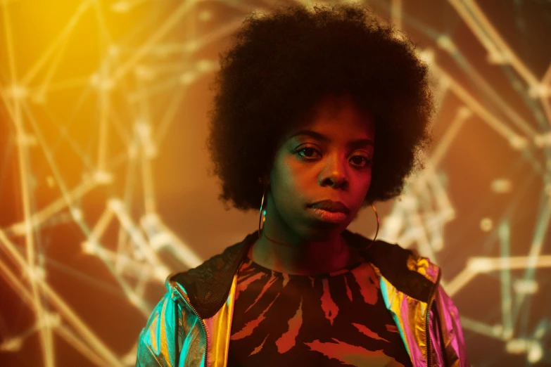 a woman with an afro standing in front of a wall, afrofuturism, colourful dramatic lighting, promotional still, yellow aura, voodoo