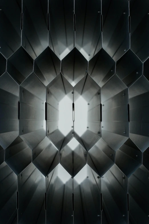 a black and white photo of a light at the end of a tunnel, by Jacob Toorenvliet, conceptual art, honeycomb structure, c 4 d ”, metal panels, gradient and patterns wallpaper