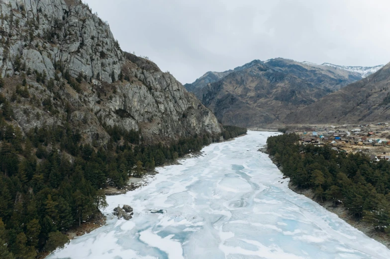 a river running through a valley next to a mountain, an album cover, by Muggur, pexels contest winner, hurufiyya, on the frozen danube, thumbnail, a high angle shot, wide film still