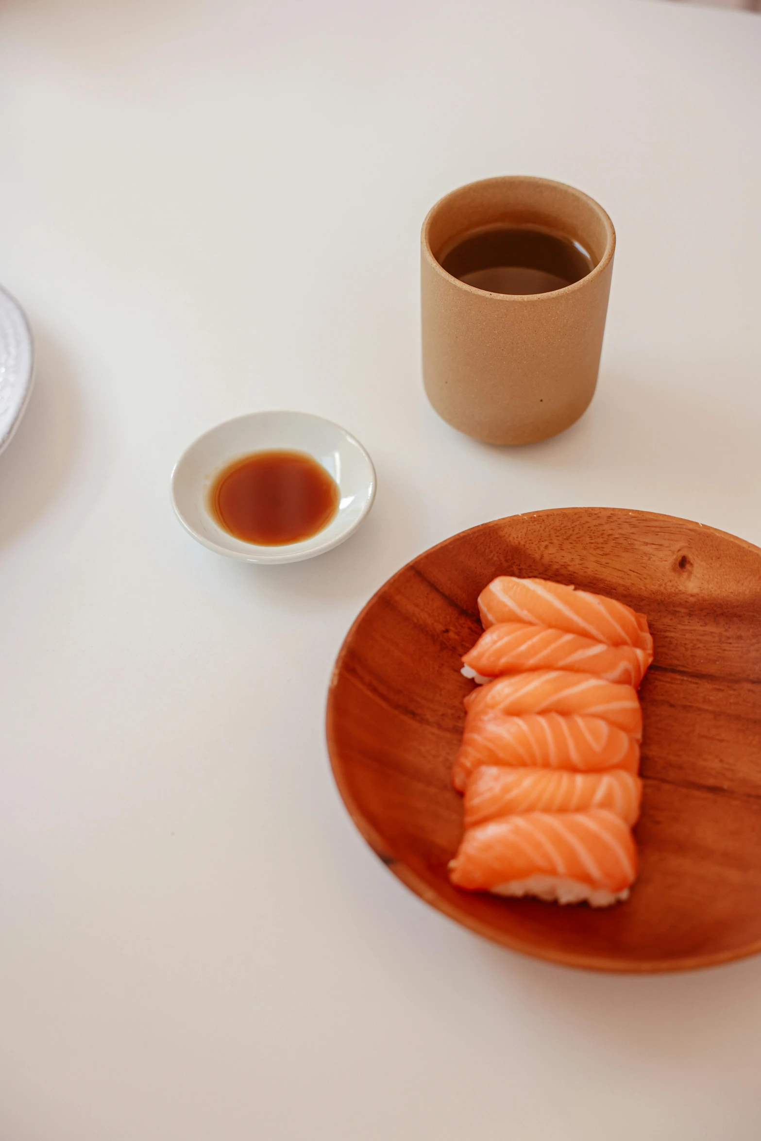 a close up of a plate of food on a table, inspired by Tōshi Yoshida, purism, coffee cup, salmon, john pawson, wood cups