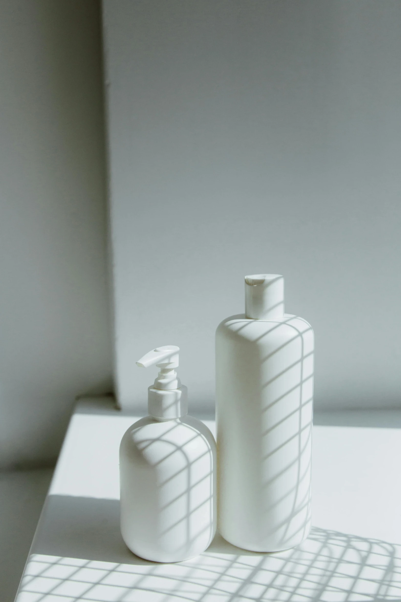 a couple of bottles sitting on top of a table, an ambient occlusion render, by Shigeru Aoki, unsplash, minimalism, porcelain highlighted skin, soft window light, milk - bath effect, hair detailing