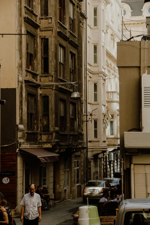 a group of people walking down a street next to tall buildings, a picture, by irakli nadar, pexels contest winner, renaissance, old apartment, solid background, turkey, photograph of san francisco