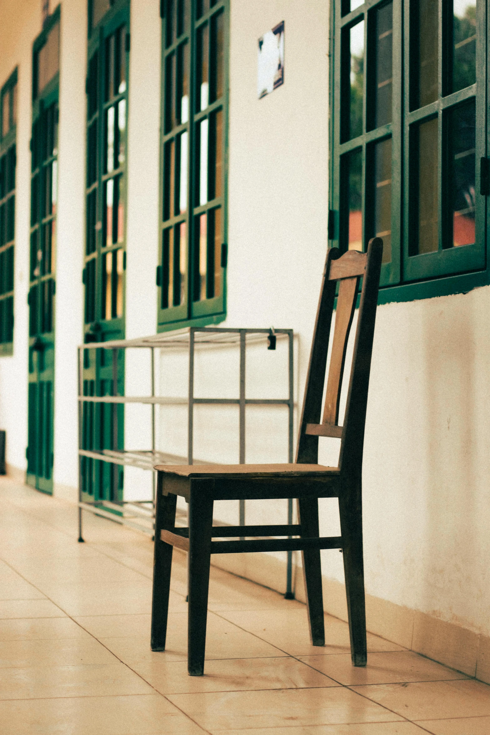 a wooden chair sitting on top of a tiled floor, unsplash, private school, vietnam, multiple stories, profile image