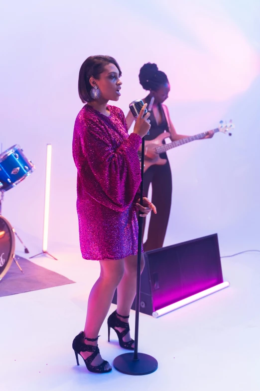 a woman in a pink dress singing into a microphone, an album cover, pexels, happening, performing a music video, at a fashion shoot, purple scene lighting, ( ( theatrical ) )