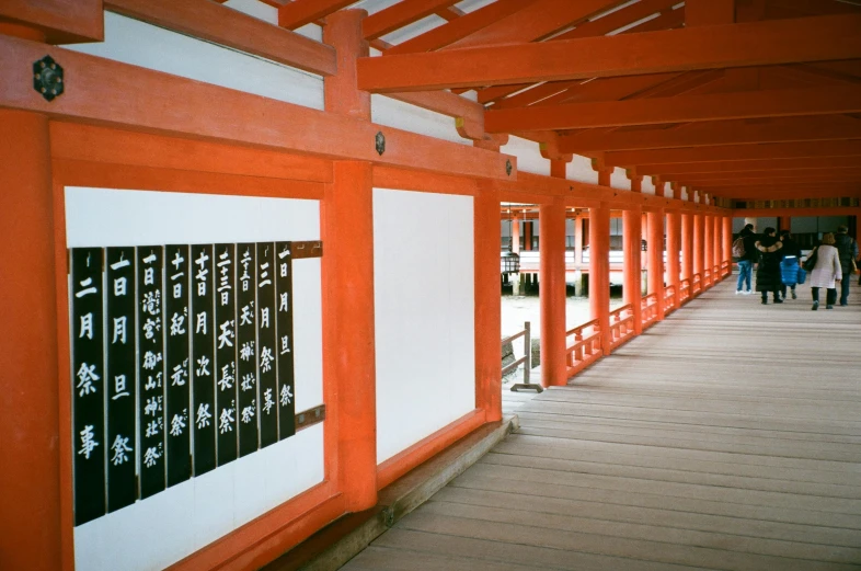 a group of people walking down a wooden walkway, a silk screen, inspired by Torii Kiyomoto, unsplash, sōsaku hanga, white and orange, colonnade, medium format, calligraphic poetry