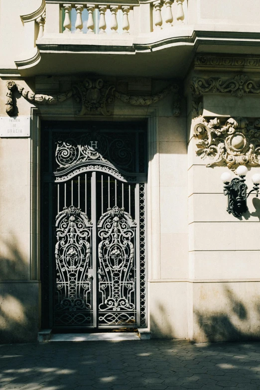 a black fire hydrant sitting in front of a building, inspired by Mihály Munkácsy, unsplash, art nouveau, iron gate door texture, mansion, buenos aires, from the distance