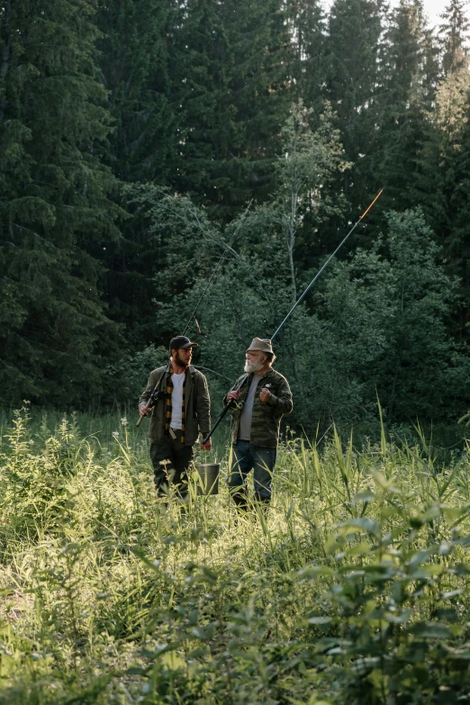 a couple of men standing on top of a lush green field, fishing pole, german forest, cinematic movie still, camaraderie