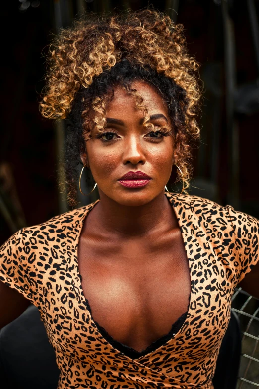 a woman in a leopard print top posing for a picture, an album cover, trending on pexels, ( brown skin ), intense colours, thumbnail, curly blond