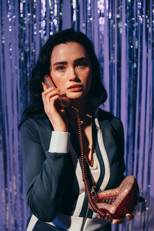 a woman holding a phone up to her ear, an album cover, inspired by Nan Goldin, magic realism, young jennifer connelly, a purple suit jacket, lilly collins, official store photo