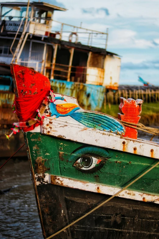 a close up of a boat on a body of water, inspired by Steve McCurry, vibrant eyes, fishing village, dilapidated look, brilliantly coloured