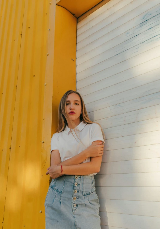 a woman leaning against a yellow wall, inspired by Elsa Bleda, pexels contest winner, realism, portrait of white teenage girl, in front of white back drop, low quality photo, multiple stories