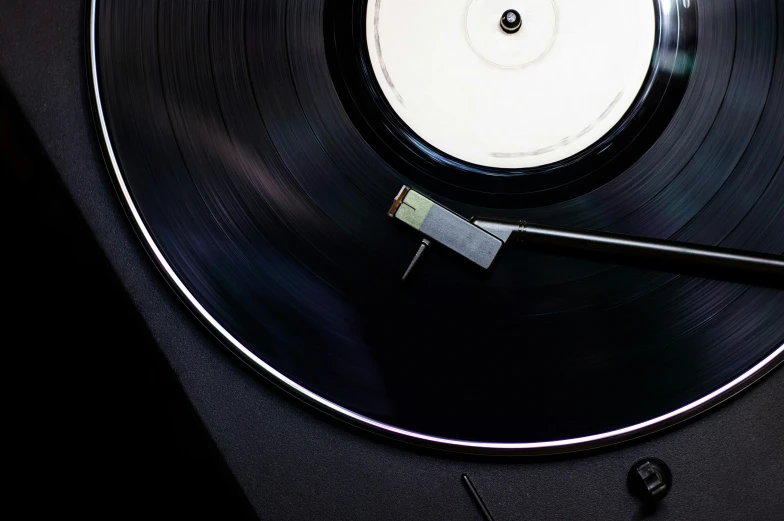 a close up of a record on a turntable, an album cover, trending on pexels, black velvet, hedi slimane, smooth metal, (night)