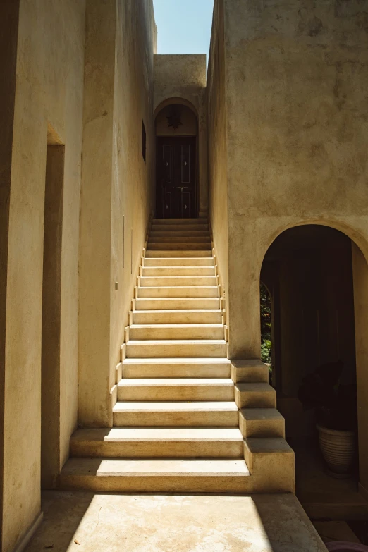 a set of stairs going up the side of a building, inspired by Ricardo Bofill, unsplash, light and space, colonial style, high arches, late afternoon light, classicism style