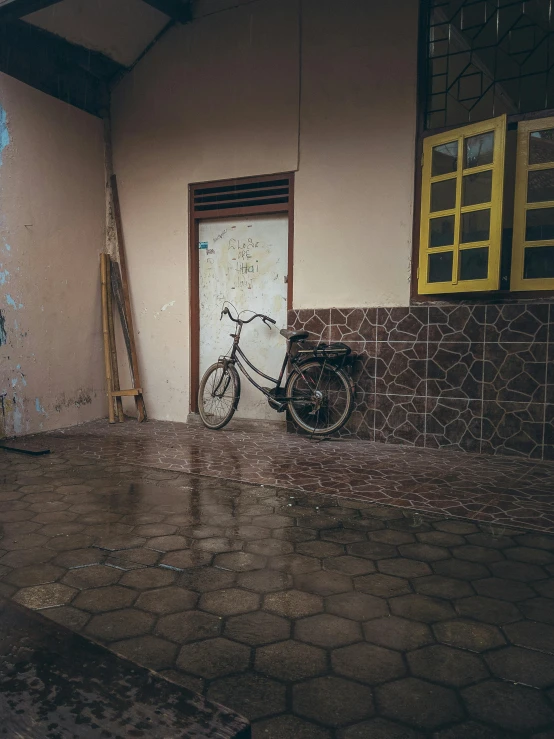 a bicycle is parked in front of a building, a picture, unsplash contest winner, hyperrealism, rainfall and mud, old jeddah city alley, low quality photo, tiled room squared waterway