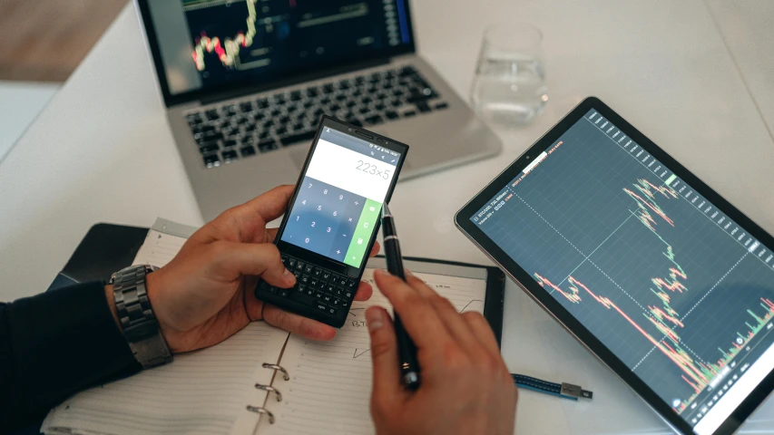 two people sitting at a table with laptops and cell phones, a photo, by Adam Marczyński, pexels, analytical art, displaying stock charts, maths, 15081959 21121991 01012000 4k, 2 5 6 x 2 5 6 pixels