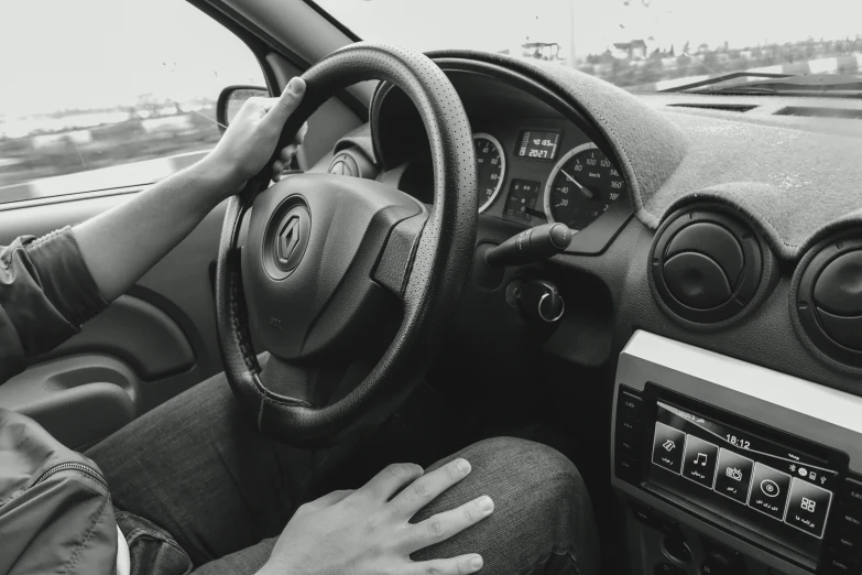 a man sitting in the driver's seat of a car, a black and white photo, pexels, renaissance, square, renault, hand controlling, ad image