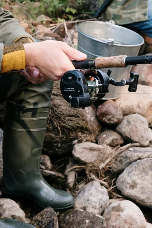 a close up of a person holding a fishing rod, black main color, adventure gear, multiple stories, black