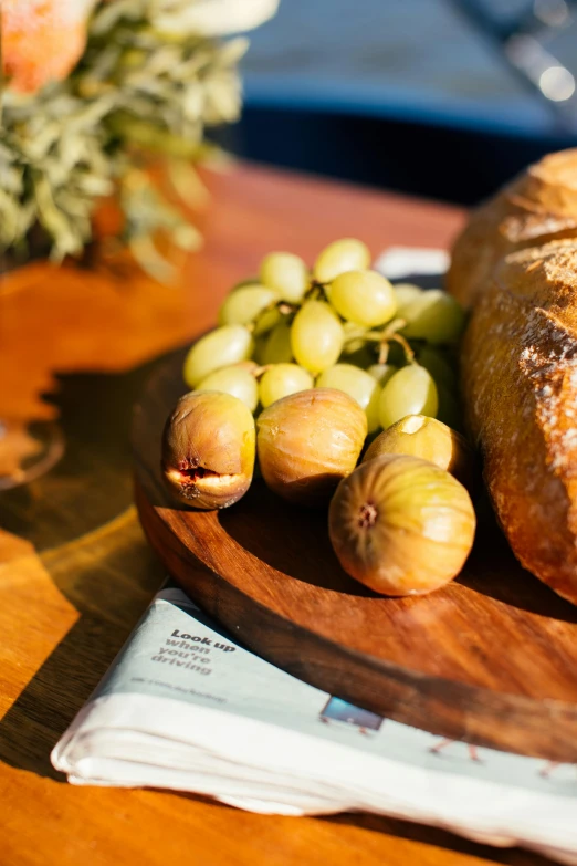 a close up of a plate of food on a table, private press, bread, grapes, local foods, great light