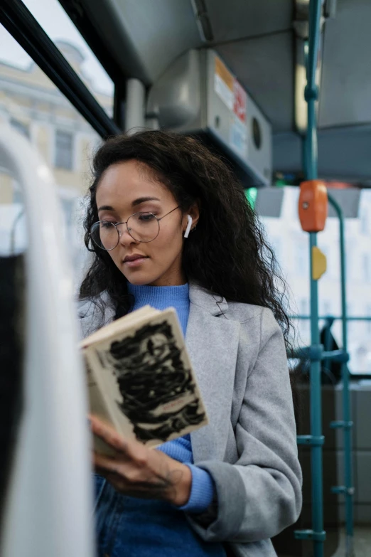 a woman reading a book on a bus, trending on pexels, happening, wearing a headset, avatar image, grayish, ashteroth