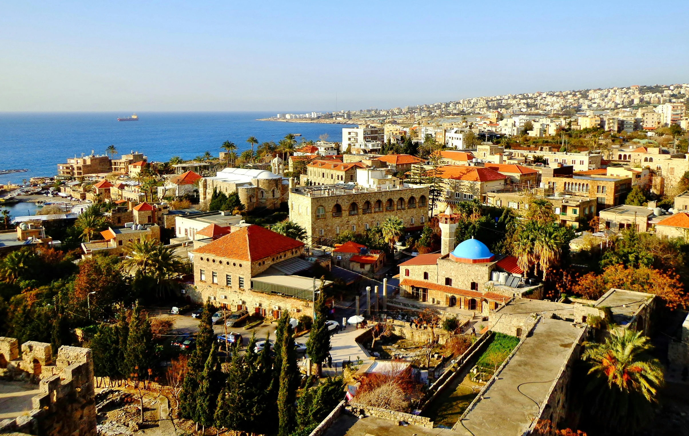 an aerial view of a city next to the ocean, lebanon kirsten dunst, paisley, well preserved, city in background