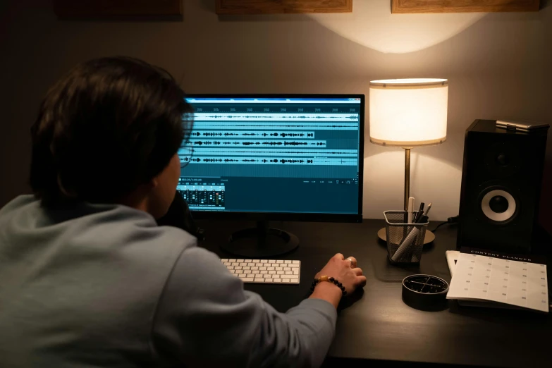 a man sitting at a desk in front of a computer, pexels contest winner, video art, cinematic volume lighting, instagram post, night shot, behind the scenes