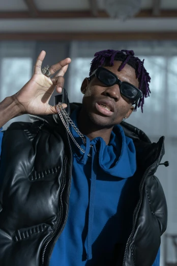 a man in a blue shirt and black jacket, an album cover, by Stokely Webster, trending on pexels, neck chains, wearing a purple sweatsuit, cold shades, joseph joestar
