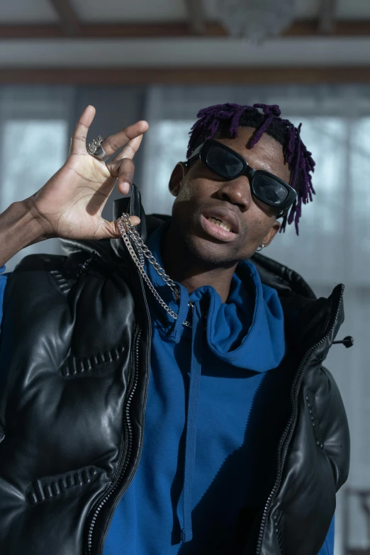 a man in a blue shirt and black jacket, an album cover, by Stokely Webster, trending on pexels, neck chains, wearing a purple sweatsuit, cold shades, joseph joestar