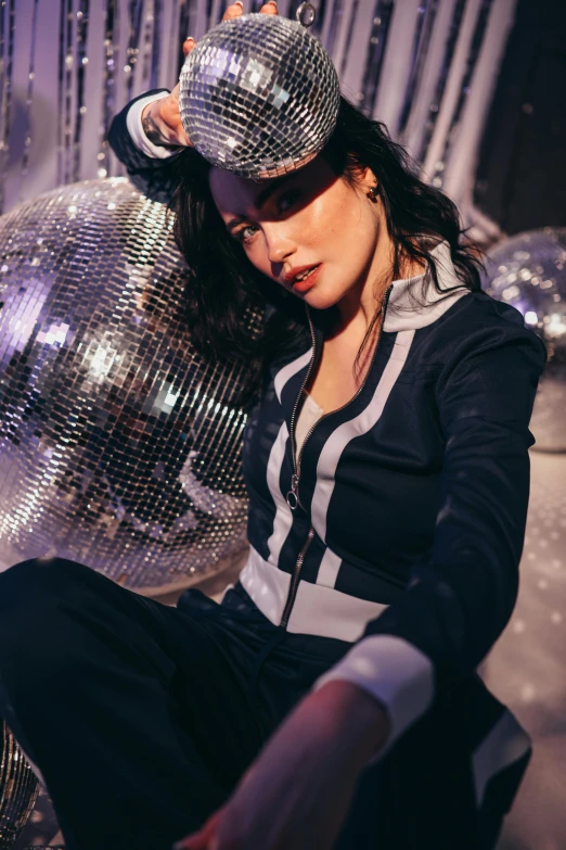 a woman sitting in front of a disco ball, federation clothing, woman with black hair, wearing a track suit, dancefloor kismet