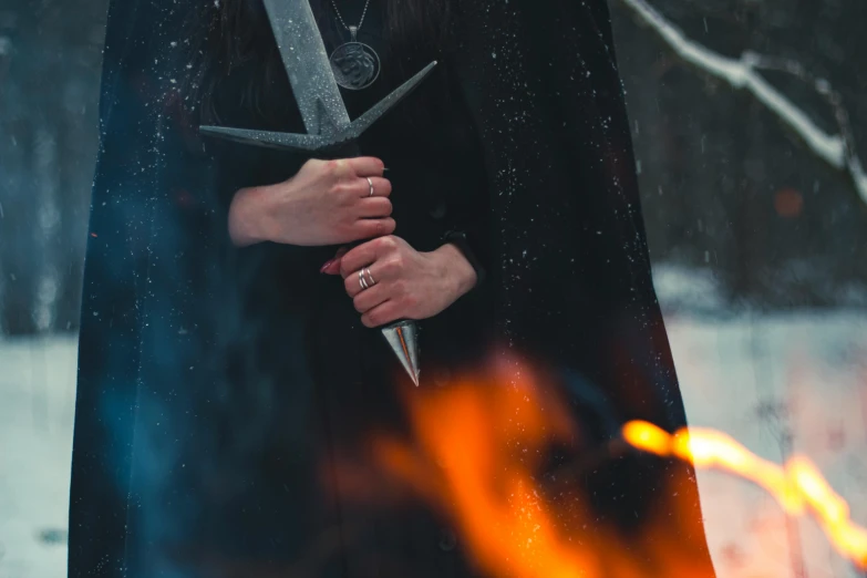 a woman holding a sword in front of a fire, pexels contest winner, scary sharp icy, background image, nordic wedding ring, instagram post