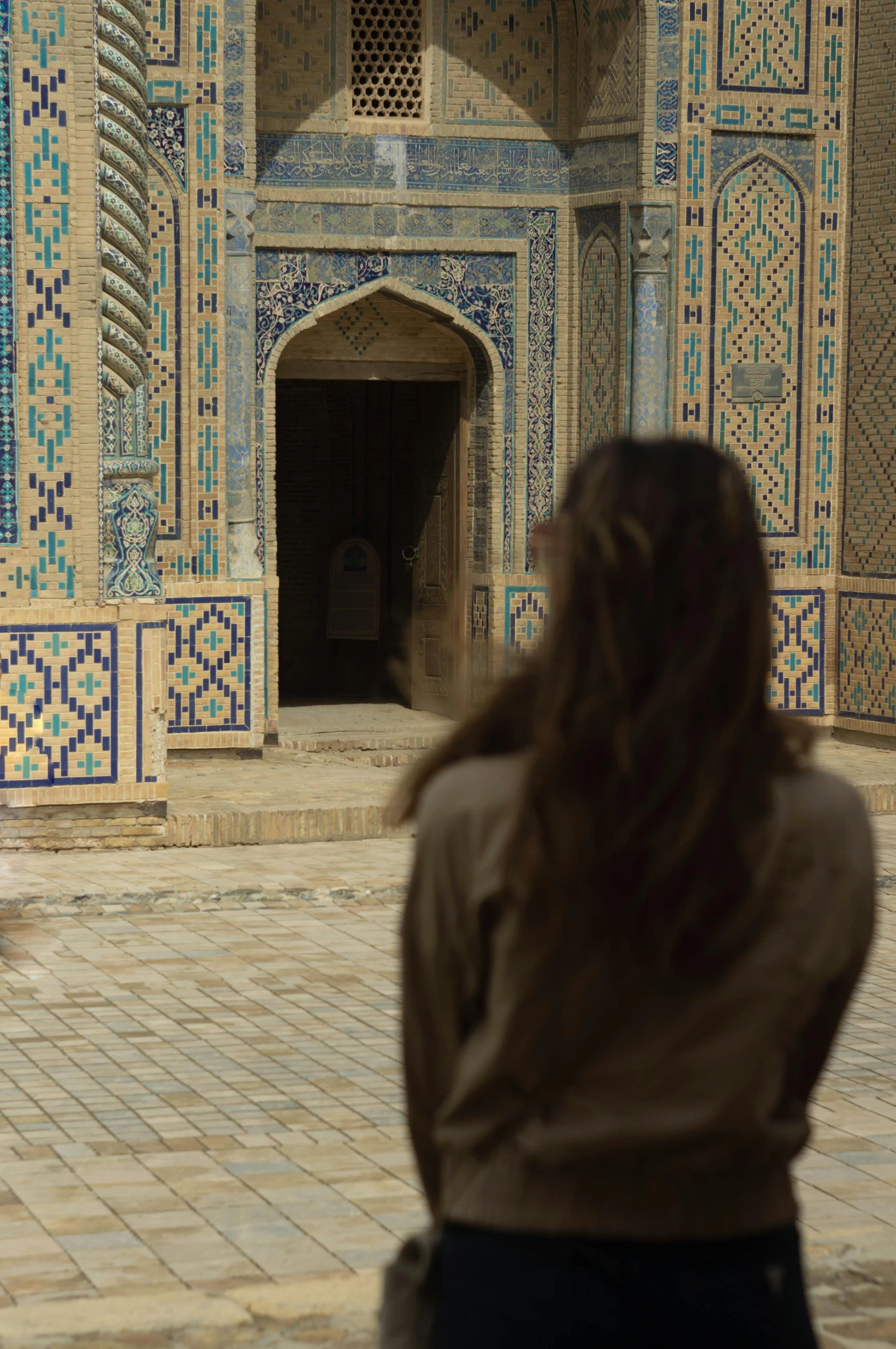 a woman standing in front of a building, inspired by Steve McCurry, arabesque, inside a tomb, still from a live action movie, samarkand, movie filmstill