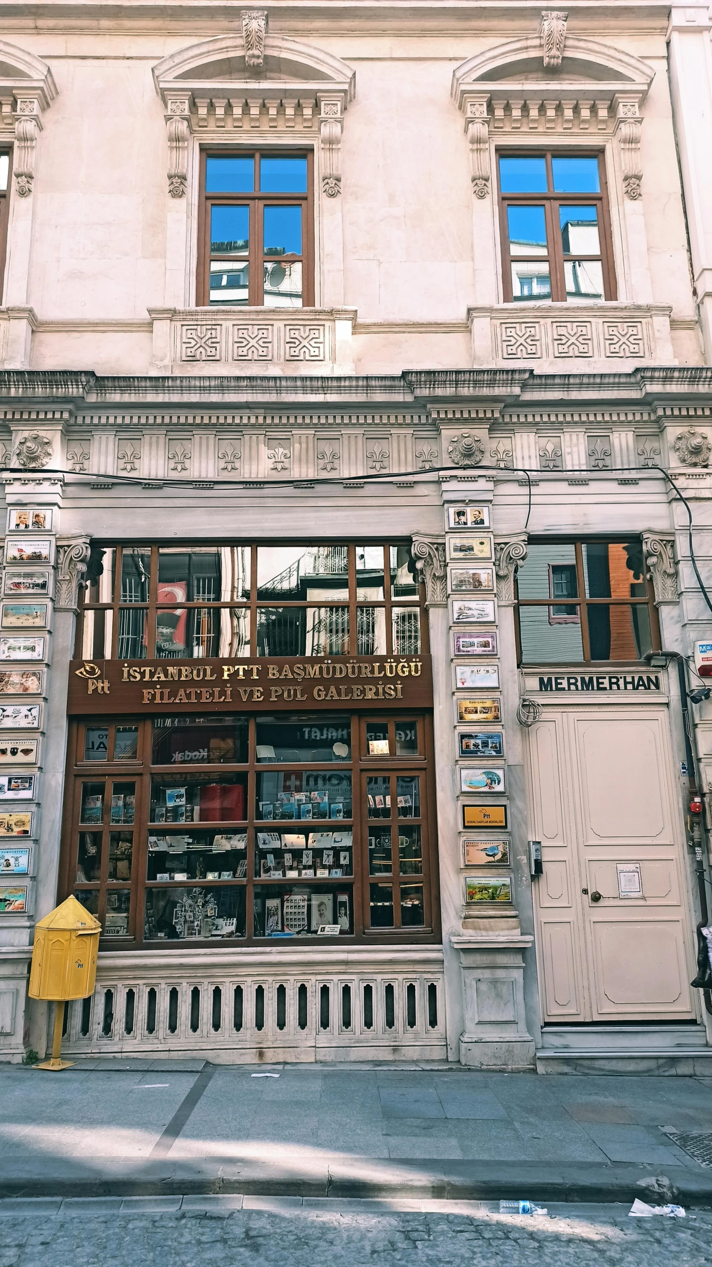 a yellow fire hydrant sitting in front of a building, an album cover, by Sam Dillemans, pexels contest winner, art nouveau, 12th century apothecary shop, istanbul, front view 1 9 9 0, exterior wide shot