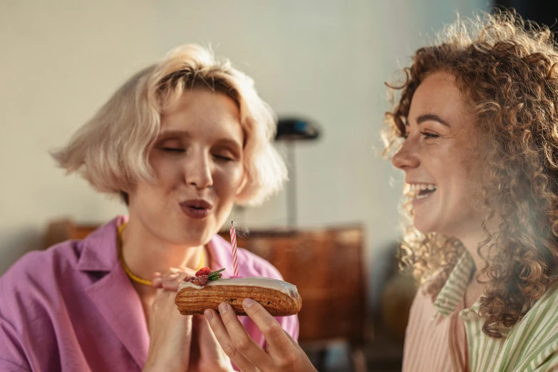 two women sitting at a table eating food, a portrait, trending on pexels, snake tongue, holding a birthday cake, blond, teeth between bread and patty