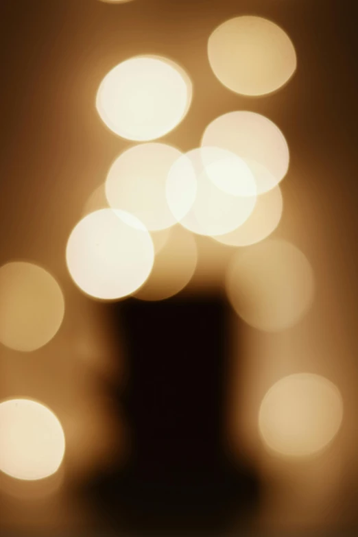 a black top hat sitting on top of a table, a picture, inspired by Henri Le Sidaner, light and space, soft diffuse lights, christmas lights, ( ( photograph ) ), ignant