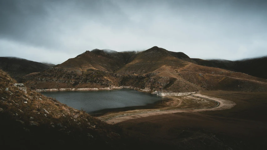 a body of water surrounded by mountains under a cloudy sky, a photo, by Alejandro Obregón, unsplash contest winner, hurufiyya, faded and dusty, water reservoir, 4 k hd wallpapear, craters